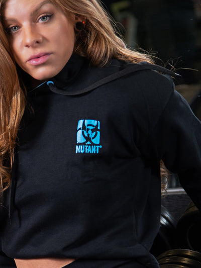 Shelby Guillaume wearing a black Mutant Thick Script Women's Gym Crop Hoodie. The hoodie features a blue Mutant logo on the chest.